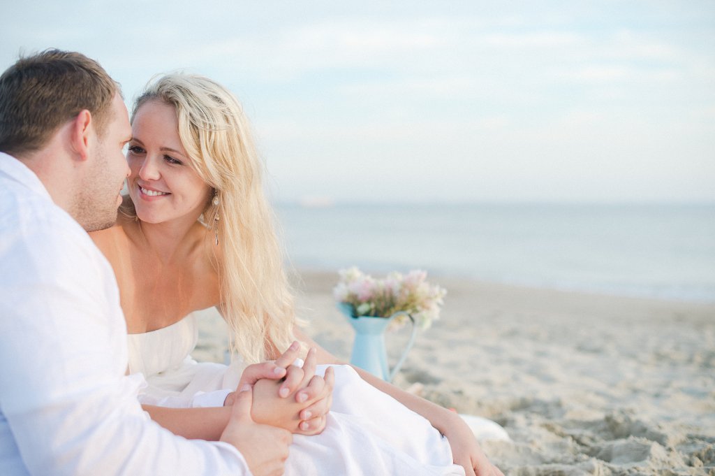 Photo Strandhochzeit, Braut sitzt auf Picknickdecke
